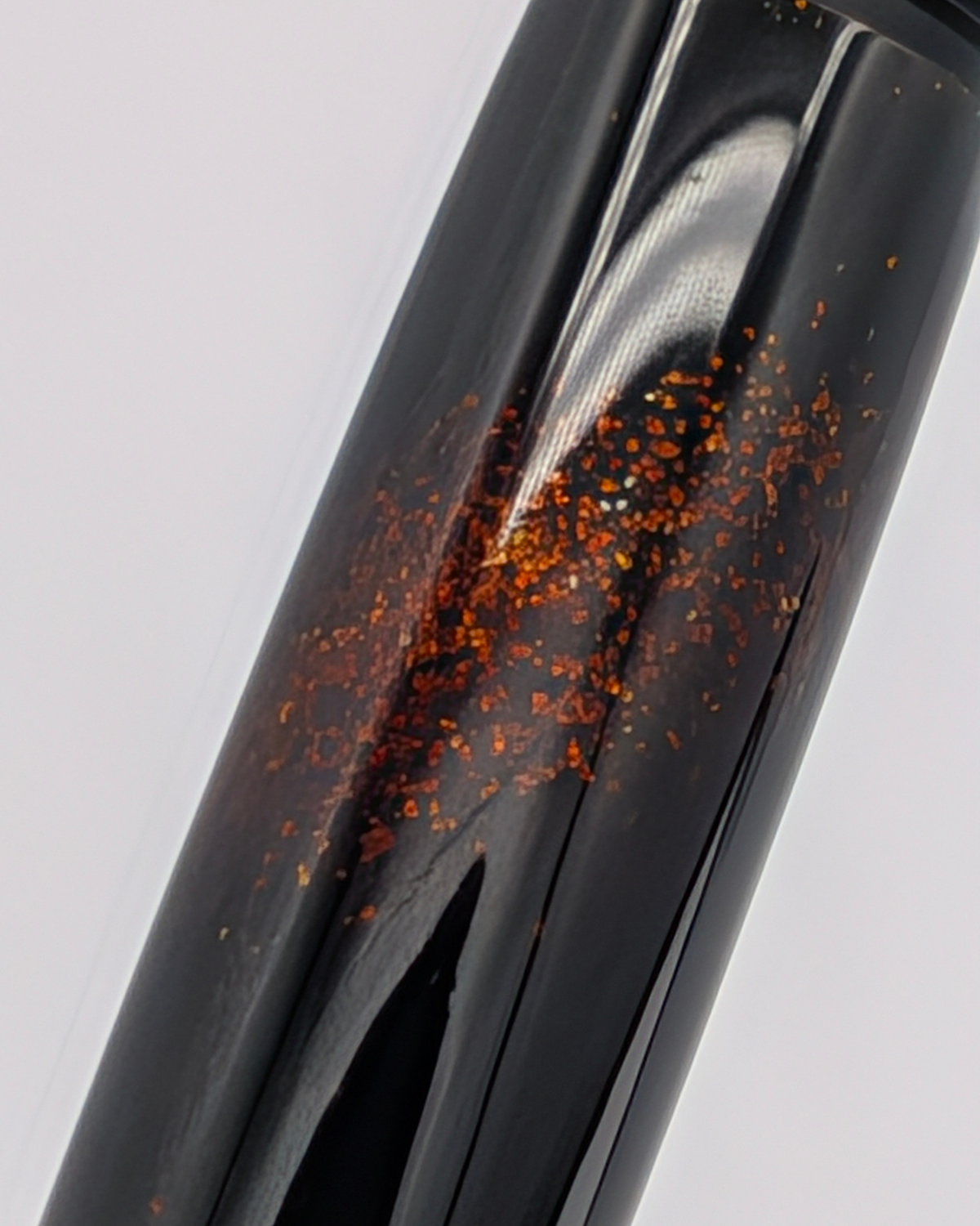 Macro of gold powder set into the black lacquer of the Liberum Star Shine barrel