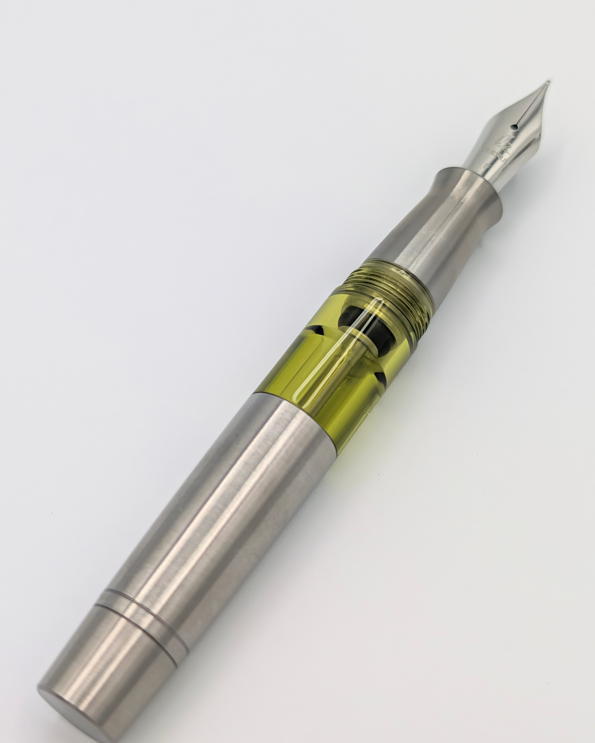 Liberum Volucris Vac Titanium fountain pen uncapped with a #6 stainless steel nib and ink window